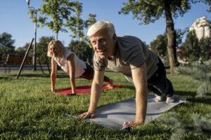 pareja-ancianos-practicando-yoga-al-aire-libre